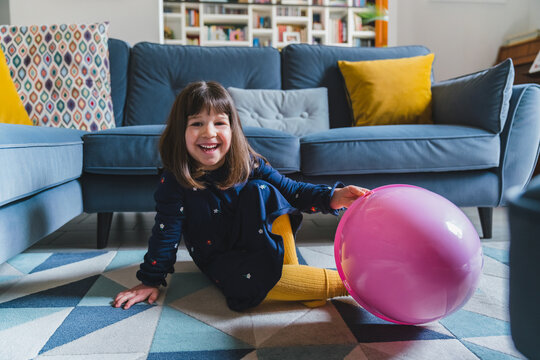 Little Girl Playing with Pink Easter Egg at Home