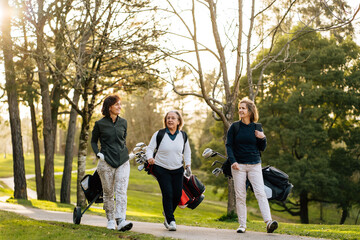 Golfer women carrying clubs 