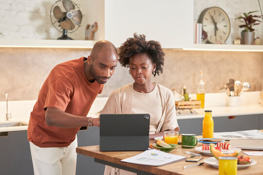 Husband helps his wife with tablet.