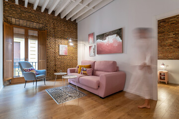 Blurred woman in stylish interior design of living room with loft architecture