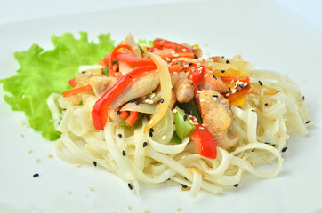 Plate of noodles with meat and vegetables isolated on white background