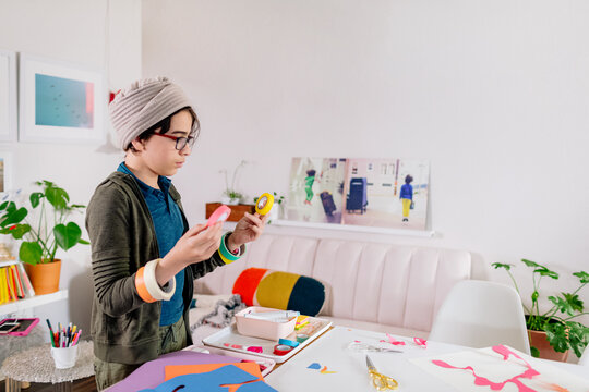Boy standing by table with craft material