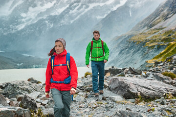 People hiking travel lifestyle. People on hike wearing backpacks in nature landscape with glacier in small icebergs in Tasman Lake on New Zealand in Aoraki Mount Cook national park.