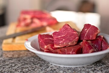Diced, fresh red meat on a deep dish. Close up.