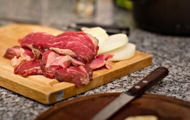 Fresh, sliced red meat on a wooden cutting board. Close up.