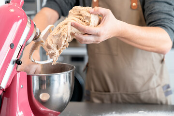 Man removing bread dough from a mixer