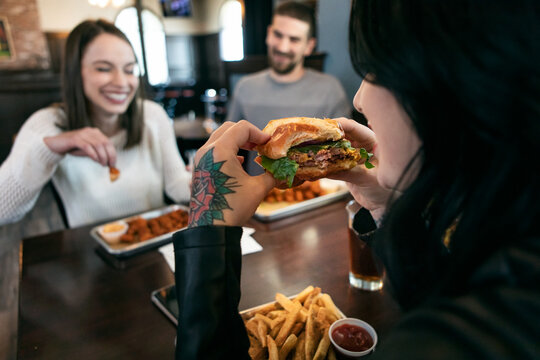 Brewery: Woman Takes A Big Bite Of Hamburger