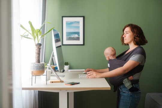 Woman With A Baby Using Computer