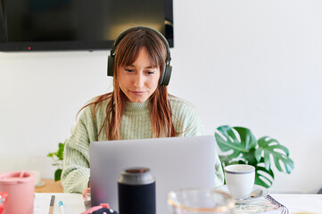 Young woman watching something on a laptop