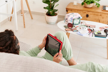 Woman in a facial mask using a digital tablet