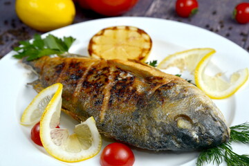 Grilled fish dorada with vegetables on the plate