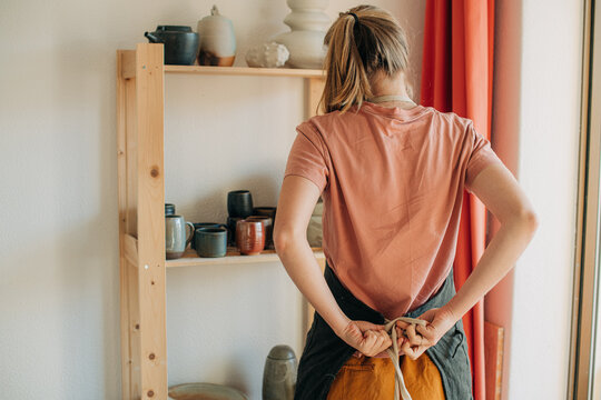 Woman tying an apron before work