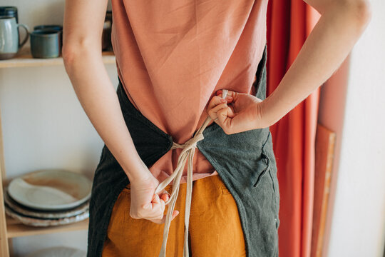 Back view of a woman tying an apron before work