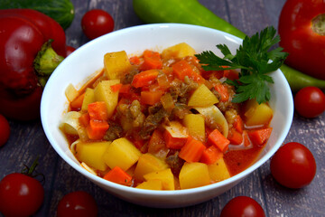Goulash, beef stew with potatoes on white plate closeup