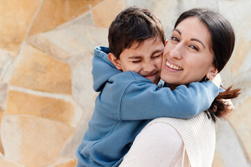 Little boy hugging his mom outside