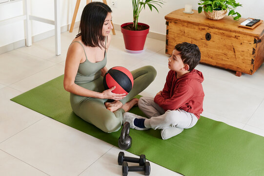 Mom and little son sitting on an exercise mat