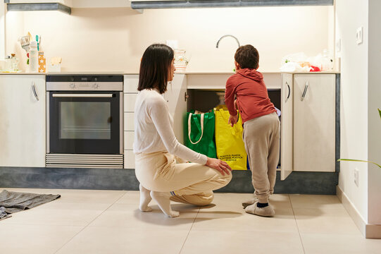 Mom teaching her little son how to recycle