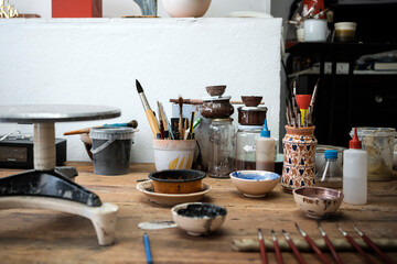 Table of a pottery workshop full of tools to work with.