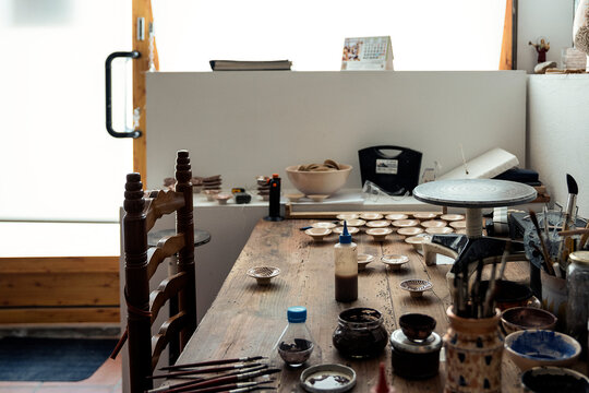 Pottery workshop with different bowls, brushes and tools
