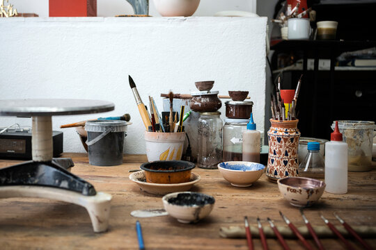 Table of a pottery workshop full of tools to work with.