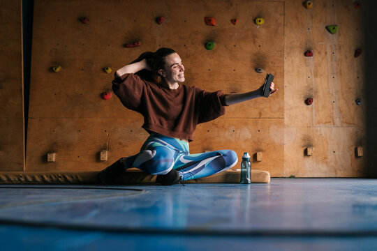 Cheerful female climber taking a selfie in a climbing centre