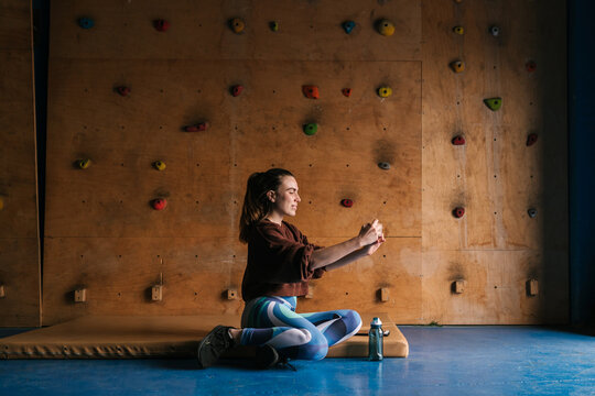 Smiling female alpinist taking selfie in climbing center