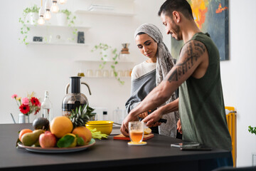Muslim couple preparing healthy food and talking