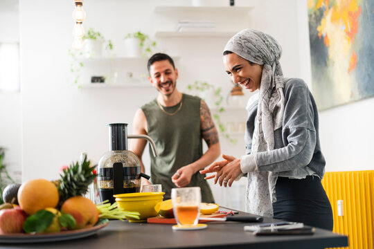 Muslim couple preparing healthy food and talking