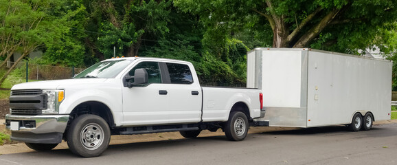 White pickup truck and large utility trailer parked on residential city street. - Powered by Adobe