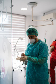 Veterinarian taking off his surgery clothes