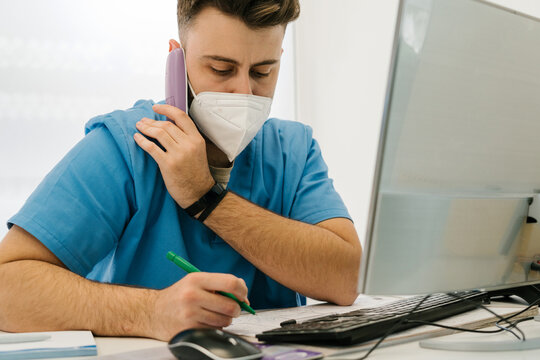 Veterinarian talking on the phone and writing in a notebook in a
