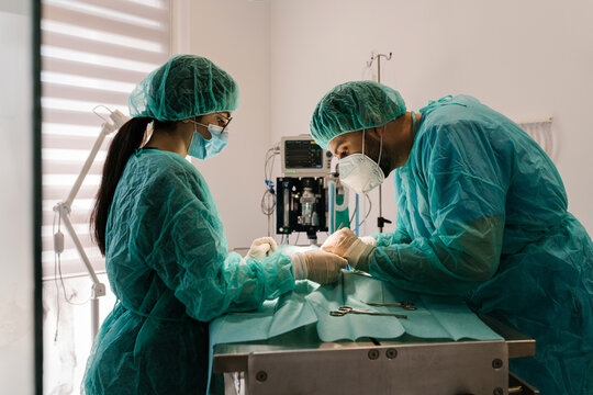 Team of surgeons in sterile scrubs operating