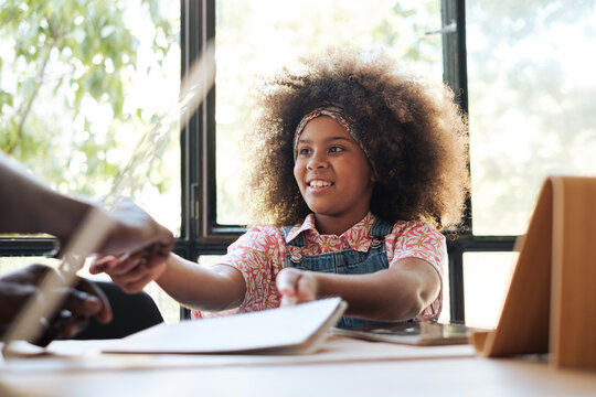 Smiling girl doing homework in the livingroom 