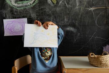 Little kid showing the picture at school home