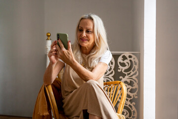 senior woman looking her phone at home