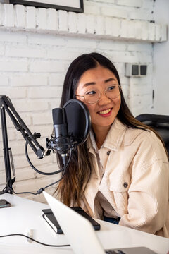 Asian woman recording an online podcast  