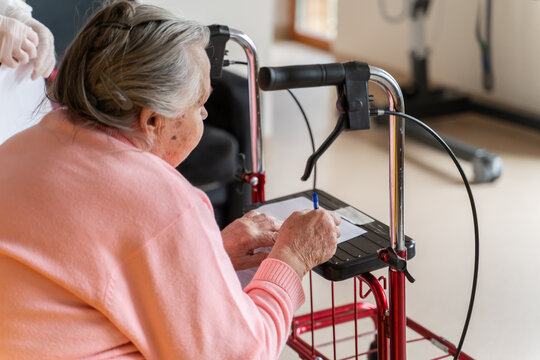 Close Up Of Senior Person Signing Document 