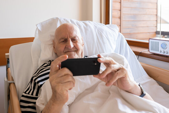 Smiling Old Man Using Smartphone