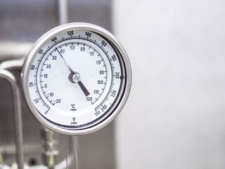 Temperature gauge for measuring instrument close up in industry zone at power plant.