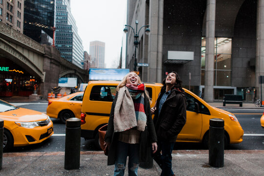 Couple excited by the snow in a city