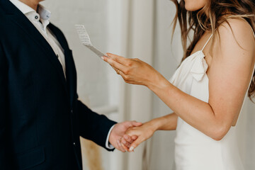 Interracial couple exchanging vows in minimalist white loft 