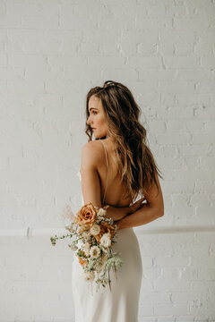 Young bride holding dried flower bouquet