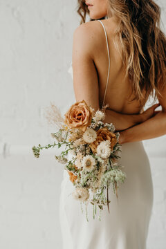 Young bride holding dried flower bouquet