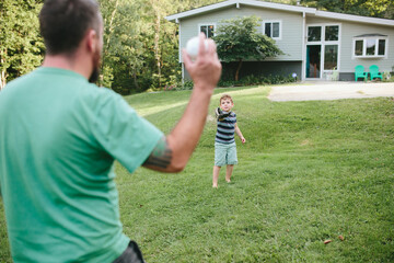 father and son play catch outside