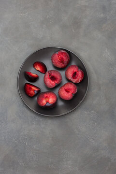 A minimal decoration with a black dish with plums