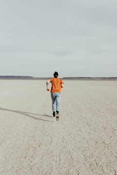 Trendy Young Man Running in the desert