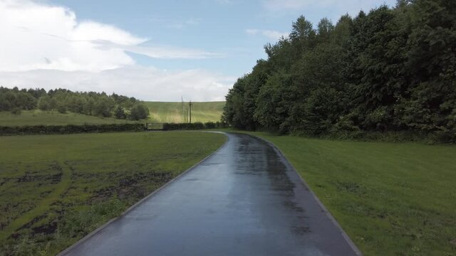 The road after the rain. Country landscape. Power lines. Forest and field.