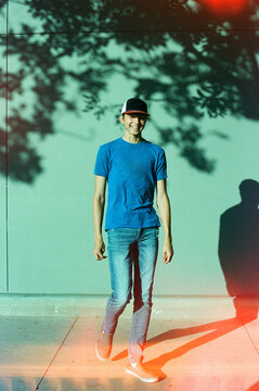 Smiling teen boy walking down sidewalk