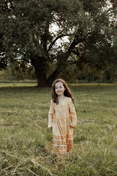 Cute, little girl walking across a field 