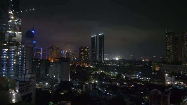night time illumination jakarta city downtown construction rooftop panorama 4k indonesia